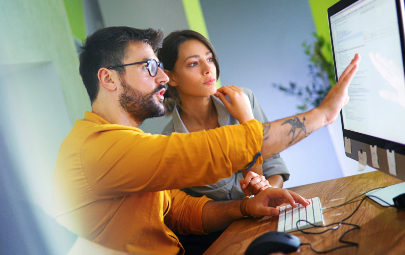 Two professionals analyzing data on a computer screen to find winning products for dropshipping.